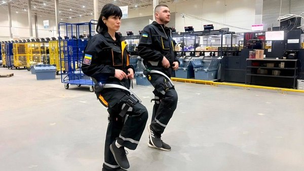 Поштовий оператор перевіряє екзоскелети для робітників на київському логістичному хабі.
